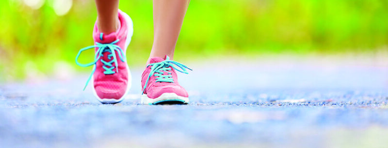 Person running with pink athletic shoes for plantar fasciitis relief