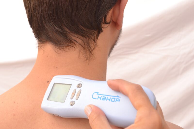 SCENAR device being used on the neck for pain relief and therapy